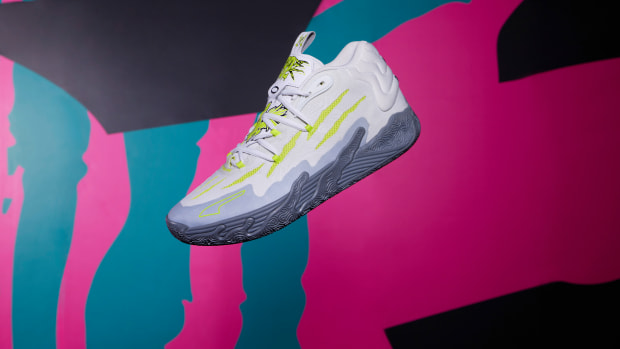 Side view of LaMelo Ball's grey and green PUMA basketball shoe.